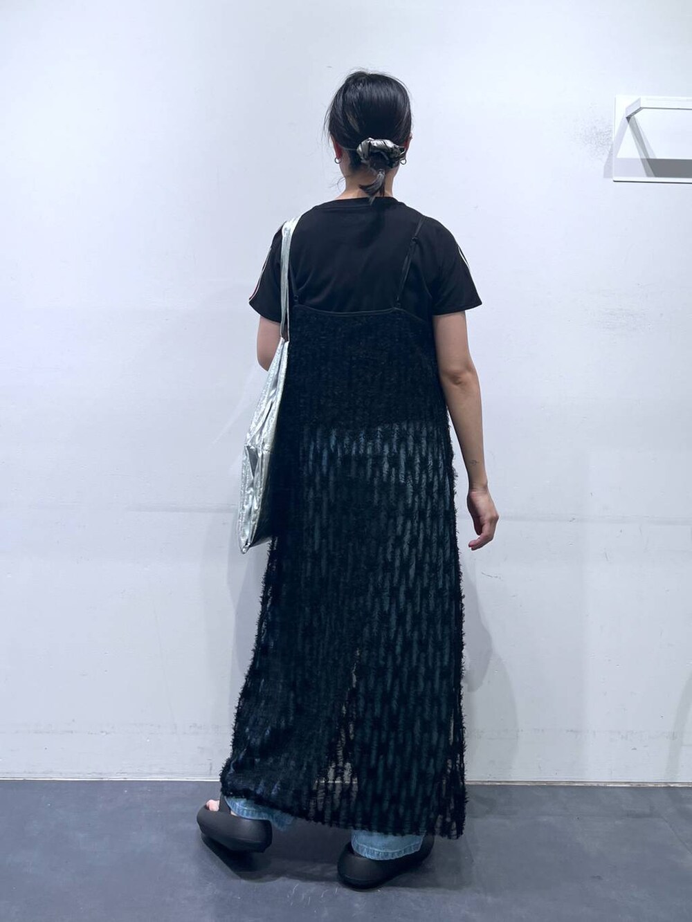 ブラック系のサンダル、シルバー系のトートバッグ、ブルー系のデニムパンツを着用したレディースの春コーディネートの5枚目の写真