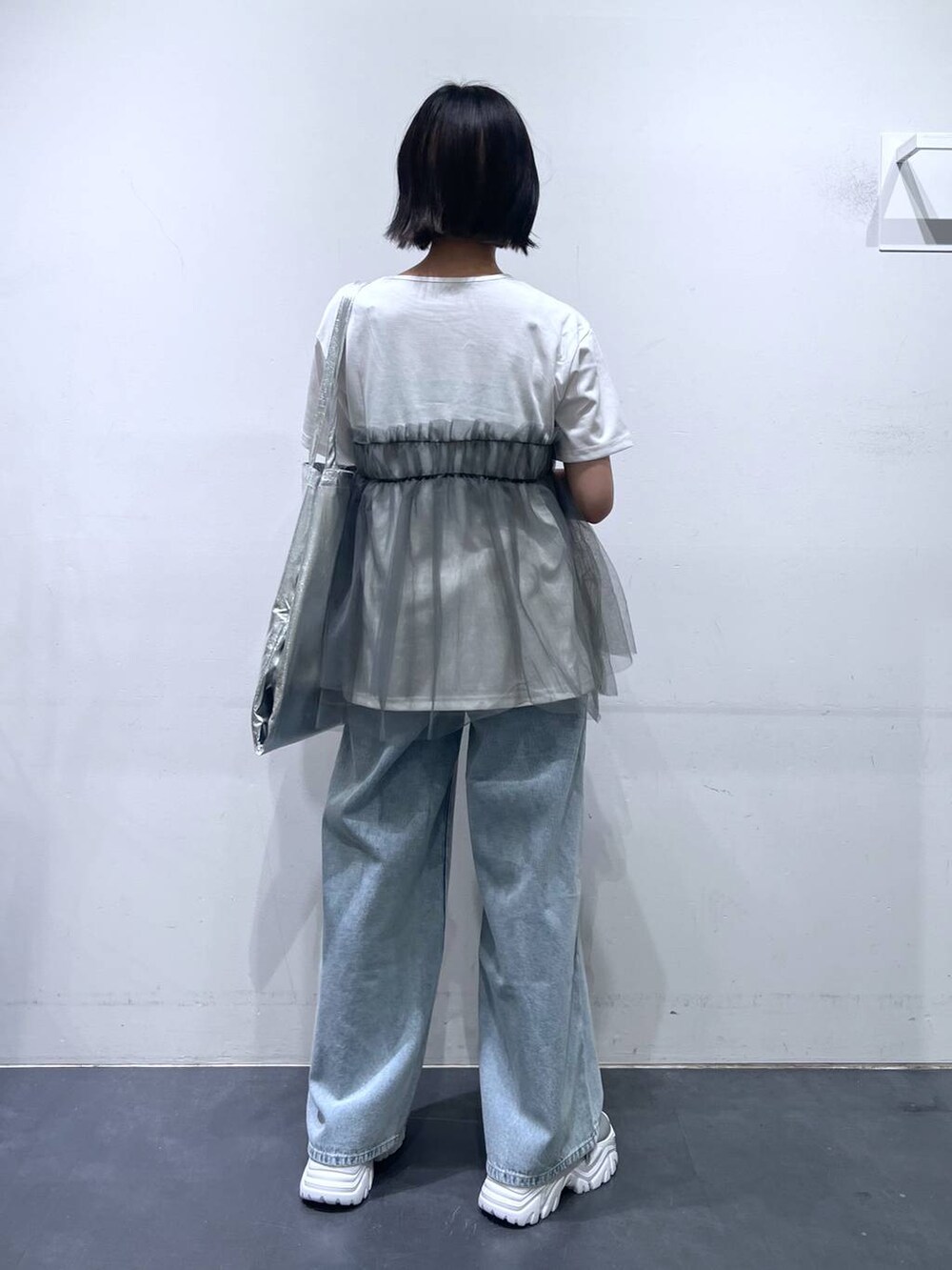 シルバー系のトートバッグ、ブルー系のデニムパンツ、グレー系のTシャツ/カットソーを着用したレディースの夏コーディネートの5枚目の写真