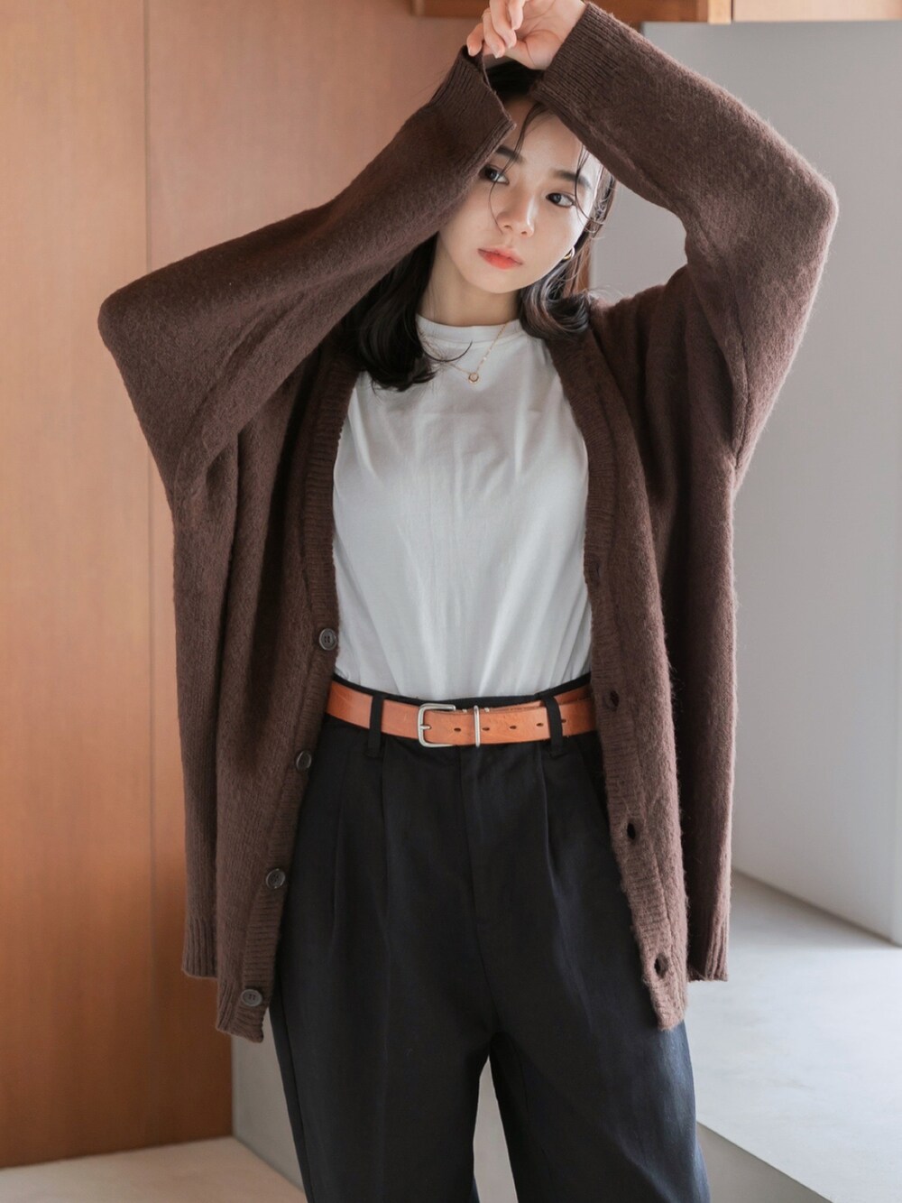 ブラック系のチノパンツ、ブラウン系のカーディガン/ボレロ、グレー系のニット/セーターを着用したレディースの秋コーディネートの2枚目の写真