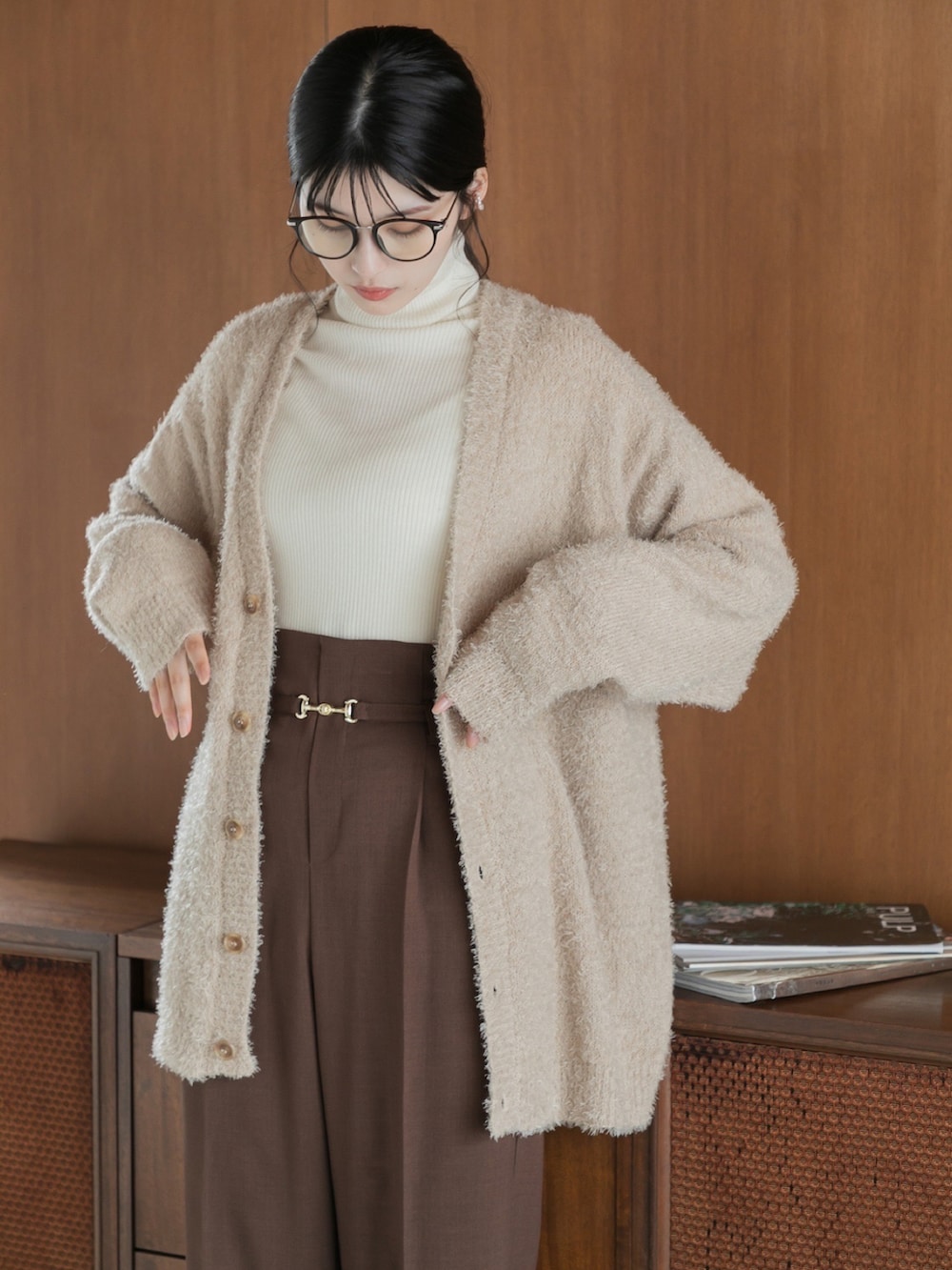 ブラウン系のスラックス、ベージュ系のカーディガン/ボレロを着用したレディースの秋コーディネートの2枚目の写真