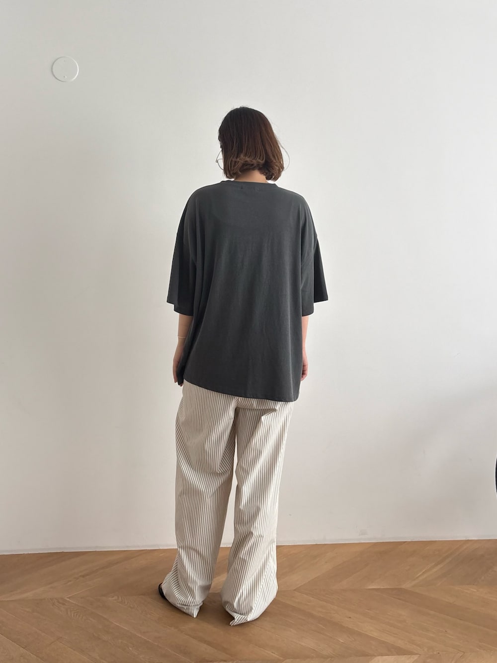 グレー系のTシャツ/カットソー、ベージュ系のその他パンツ、ブラック系のサンダルを着用したレディースの夏コーディネートの3枚目の写真