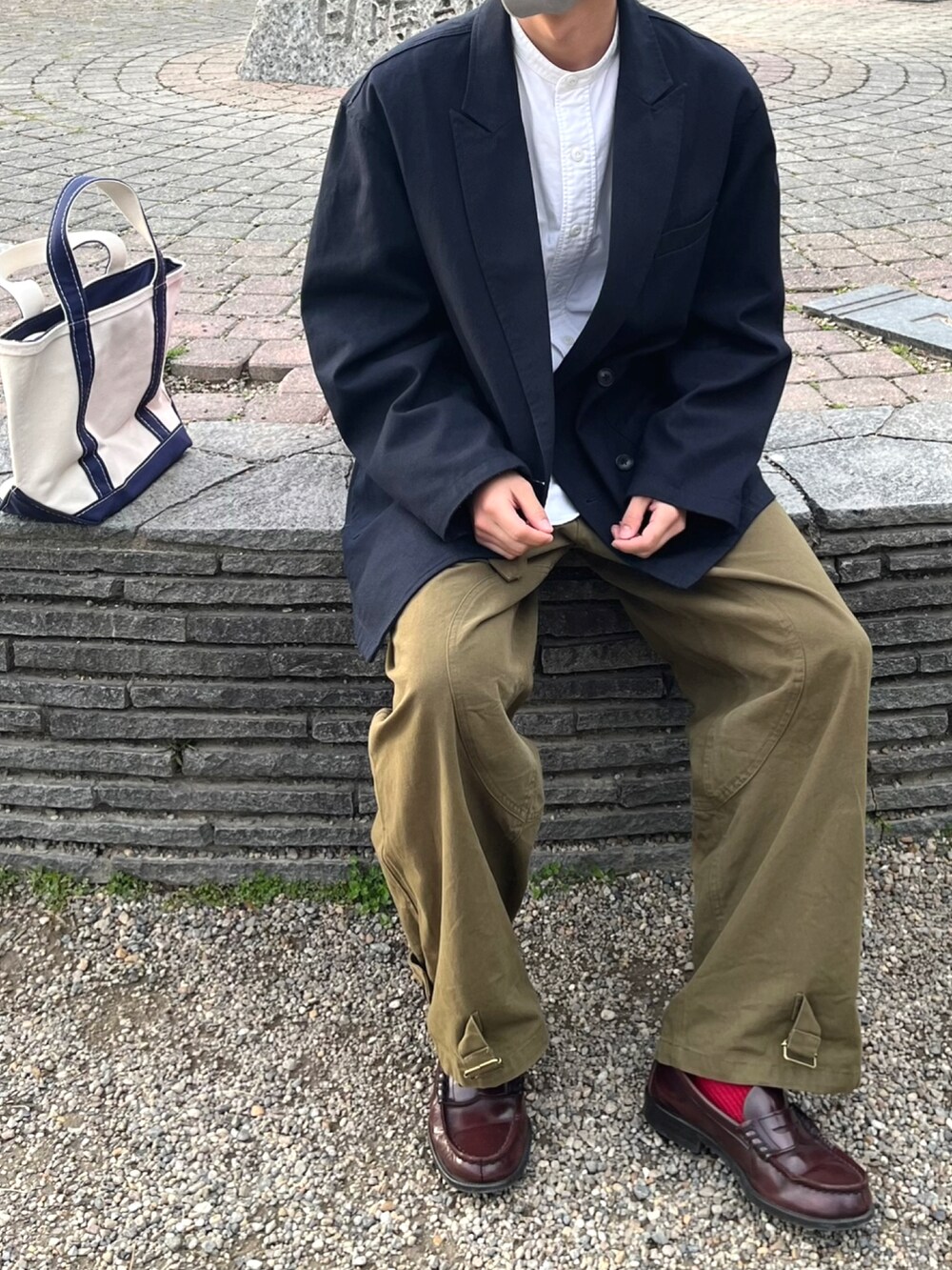 ブルー系のジャケット/アウター、グリーン系のパンツ、ホワイト系のハンドバッグを着用したメンズの秋コーディネートの2枚目の写真