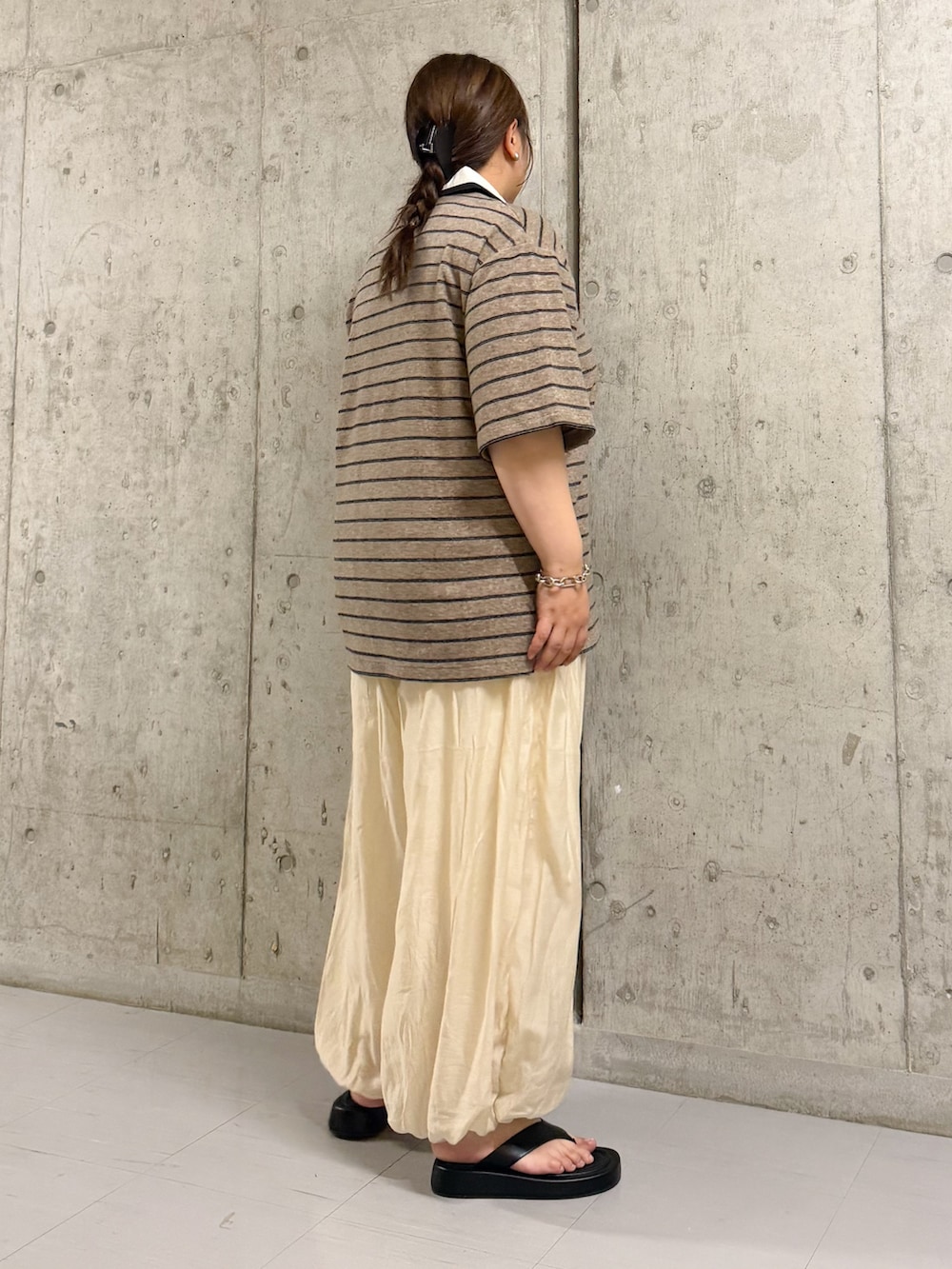 グレー系のTシャツ/カットソー、ホワイト系のその他パンツ、ブラック系のサンダルを着用したレディースの夏コーディネートの2枚目の写真