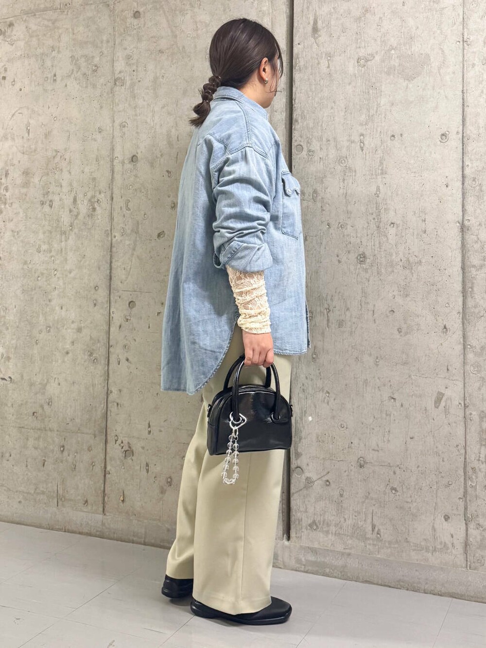 ブラック系のボストンバッグ、ブルー系のシャツ/ブラウス、ベージュ系のその他パンツを着用したレディースの春コーディネートの2枚目の写真