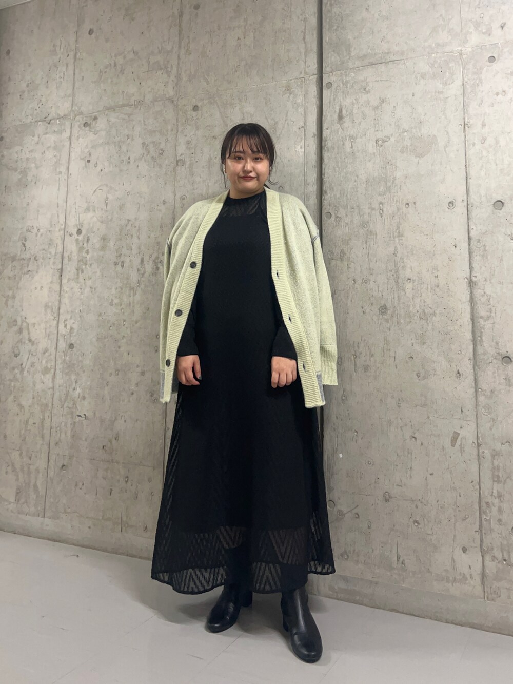 ブラック系のワンピース、ブラック系のブーツ、グレー系のカーディガン/ボレロを着用したレディースの秋コーディネートの2枚目の写真