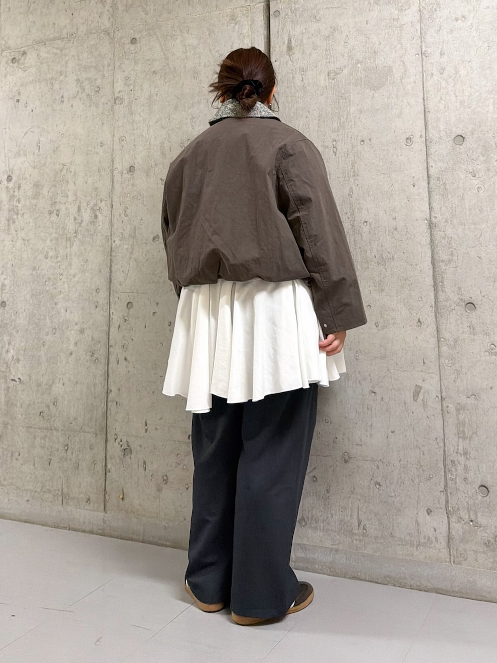 ブラウン系のブルゾン、ホワイト系のワンピース、ブラウン系のショルダーバッグを着用したレディースの冬コーディネートの2枚目の写真