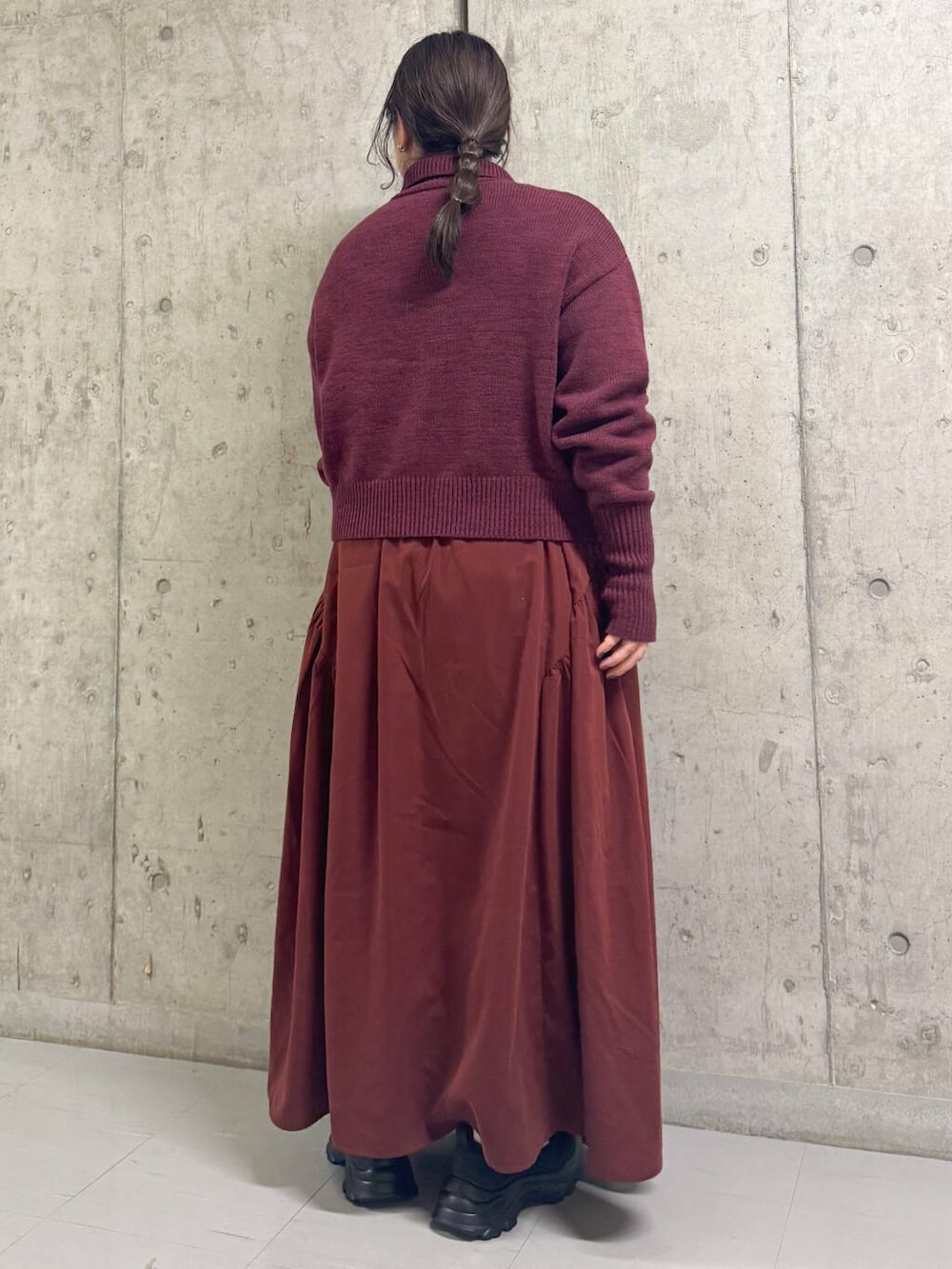 ブラック系のスニーカー、レッド系のワンピースを着用したレディースの冬コーディネートの3枚目の写真