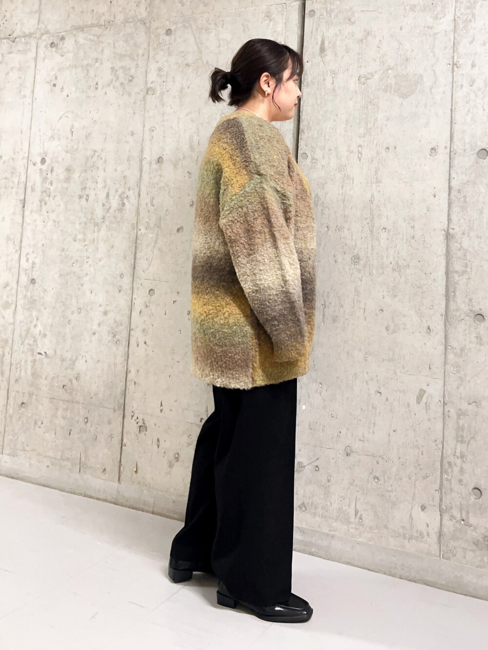 ベージュ系のタンクトップ、ブラウン系のカーディガン/ボレロ、ブラック系のパンツを着用したレディースの秋コーディネートの2枚目の写真