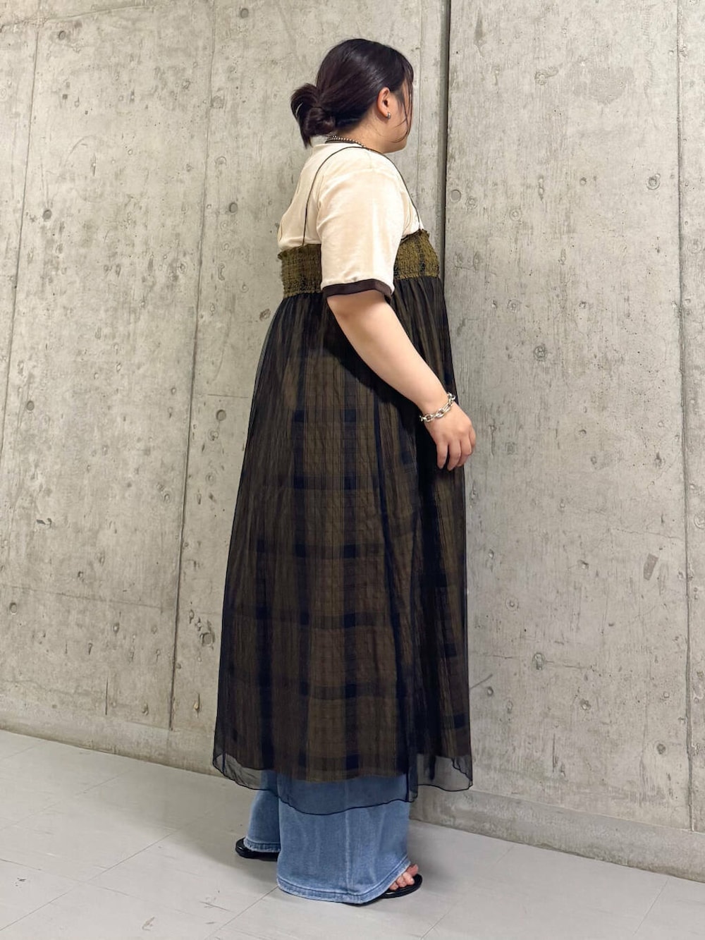 ブルー系のデニムパンツ、ベージュ系のTシャツ/カットソー、グリーン系のスカートを着用したレディースの夏コーディネートの2枚目の写真