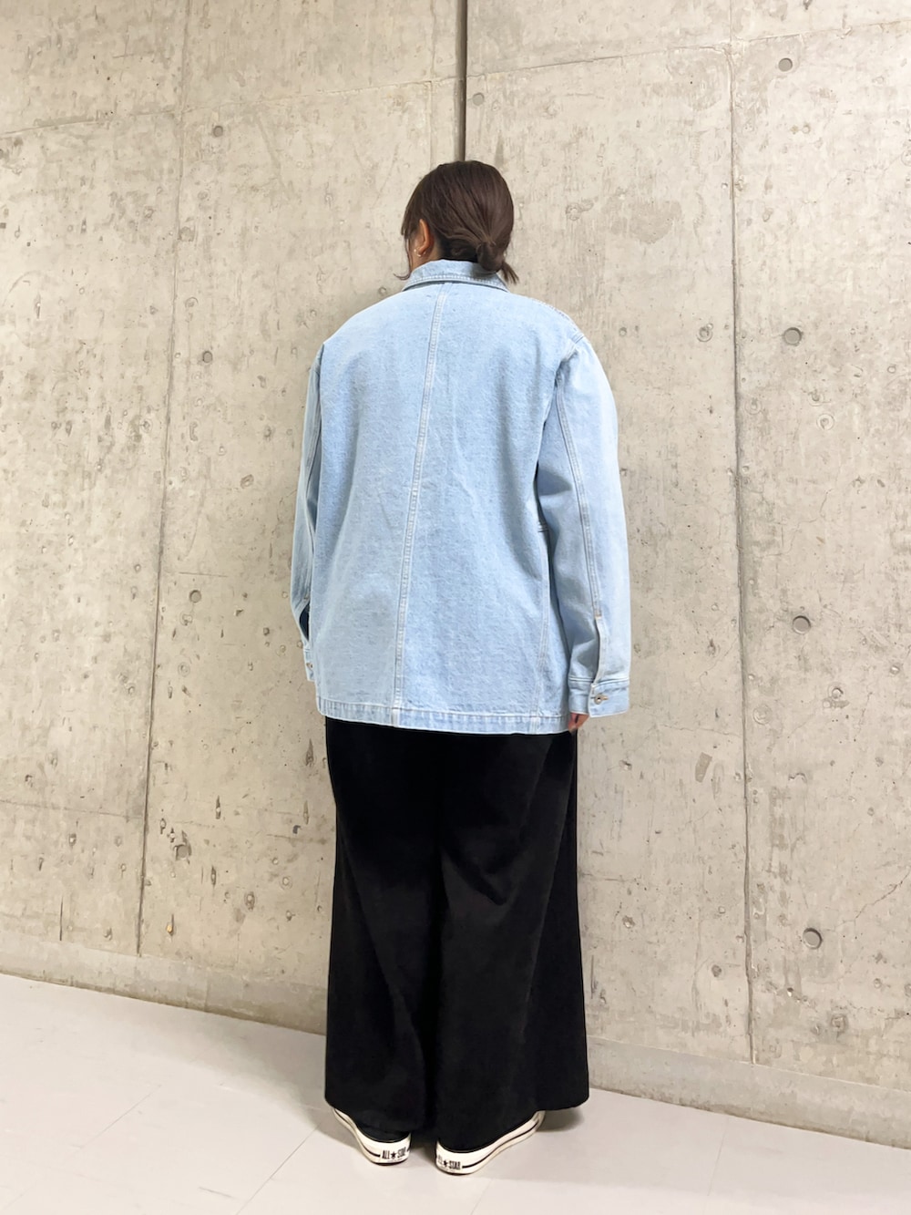 ブルー系のデニムジャケット、オレンジ系のニット/セーター、ブラック系のサロペット/オーバーオールを着用したレディースの冬コーディネートの3枚目の写真
