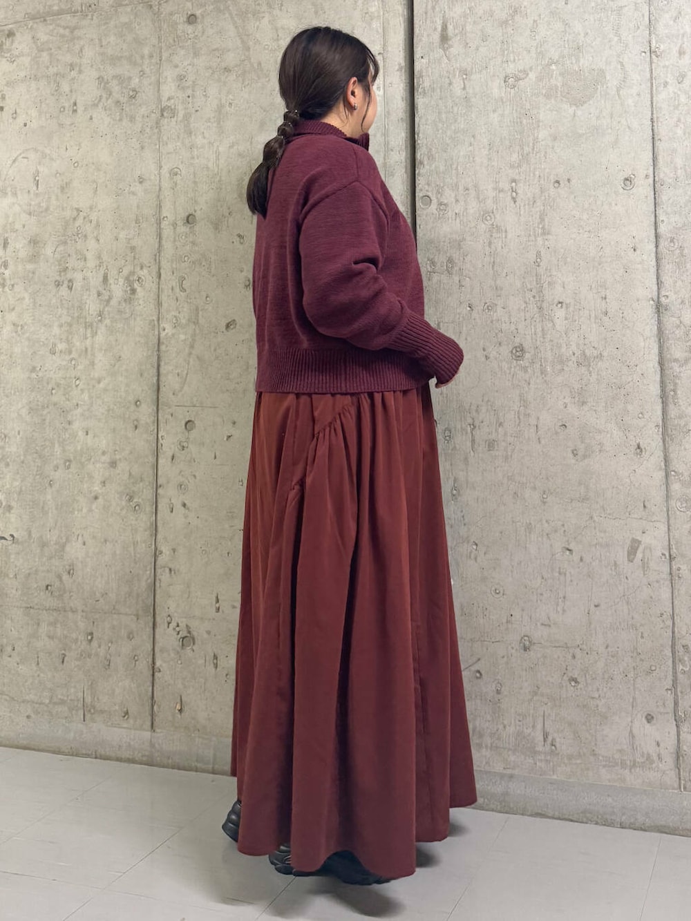 ブラック系のスニーカー、レッド系のワンピースを着用したレディースの冬コーディネートの2枚目の写真