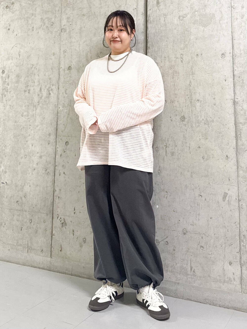 グレー系のその他パンツ、ブラック系のナイロンジャケット、ピンク系のTシャツ/カットソーを着用したレディースの春コーディネートの2枚目の写真