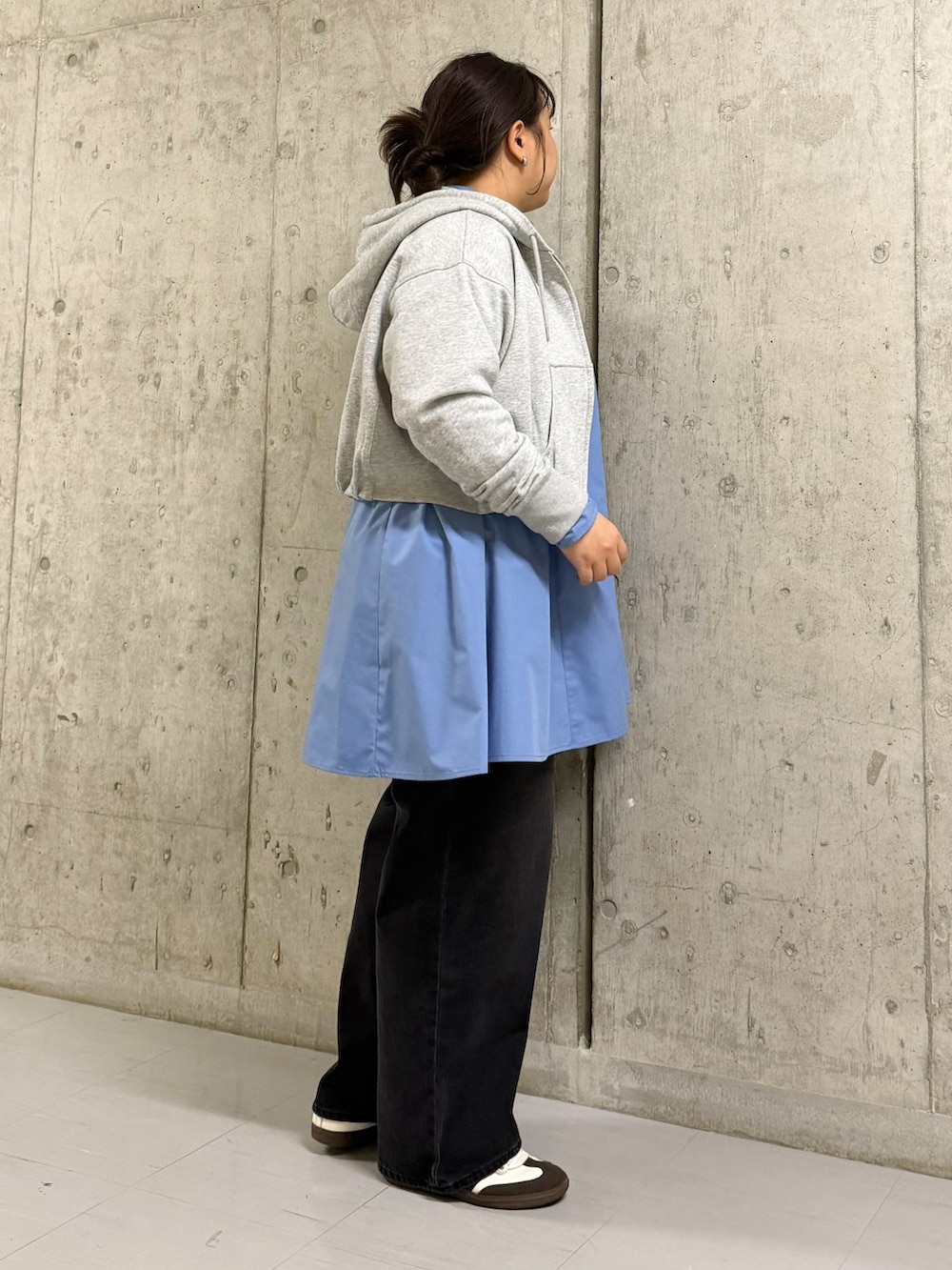 ブルー系のワンピース、グレー系のパーカー、ブラック系のデニムパンツを着用したレディースの秋コーディネートの2枚目の写真