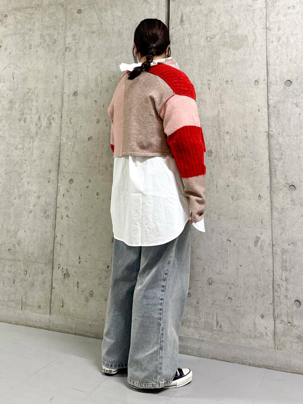 ホワイト系のワンピース、レッド系のニット/セーター、ブルー系のデニムパンツを着用したレディースの秋コーディネートの3枚目の写真