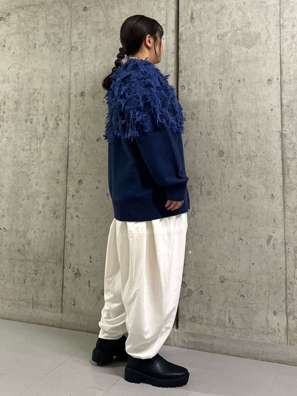 ブルー系のカーディガン/ボレロ、ホワイト系のその他パンツ、ブラック系のブーツを着用したレディースの冬コーディネートの2枚目の写真