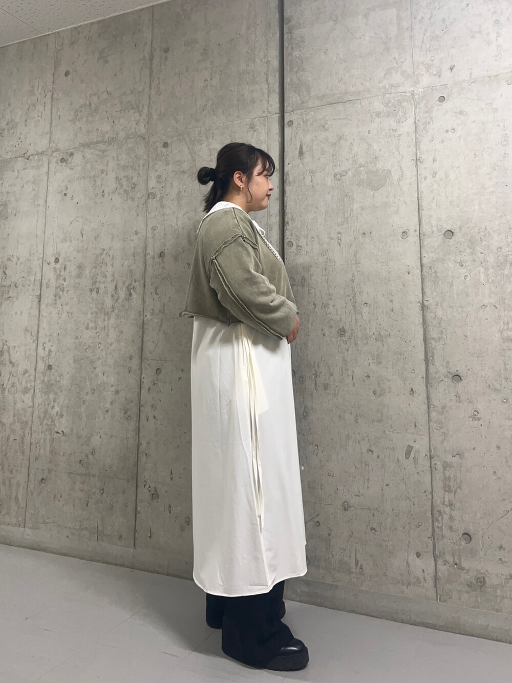 グリーン系のスウェット、ホワイト系のワンピース、ホワイト系のその他小物を着用したレディースの秋コーディネートの2枚目の写真