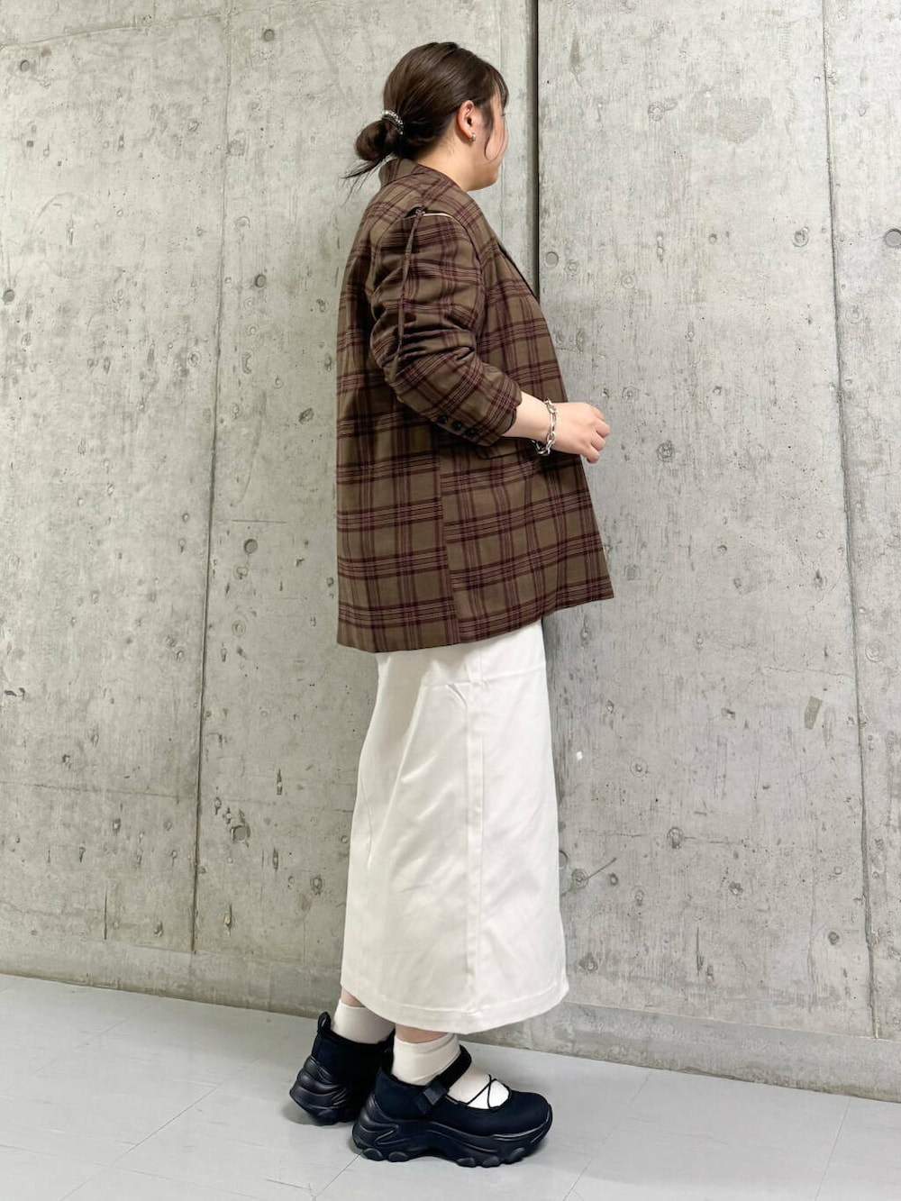 ベージュ系のスカート、ブラック系のスニーカー、レッド系のテーラードジャケットを着用したレディースの秋コーディネートの2枚目の写真