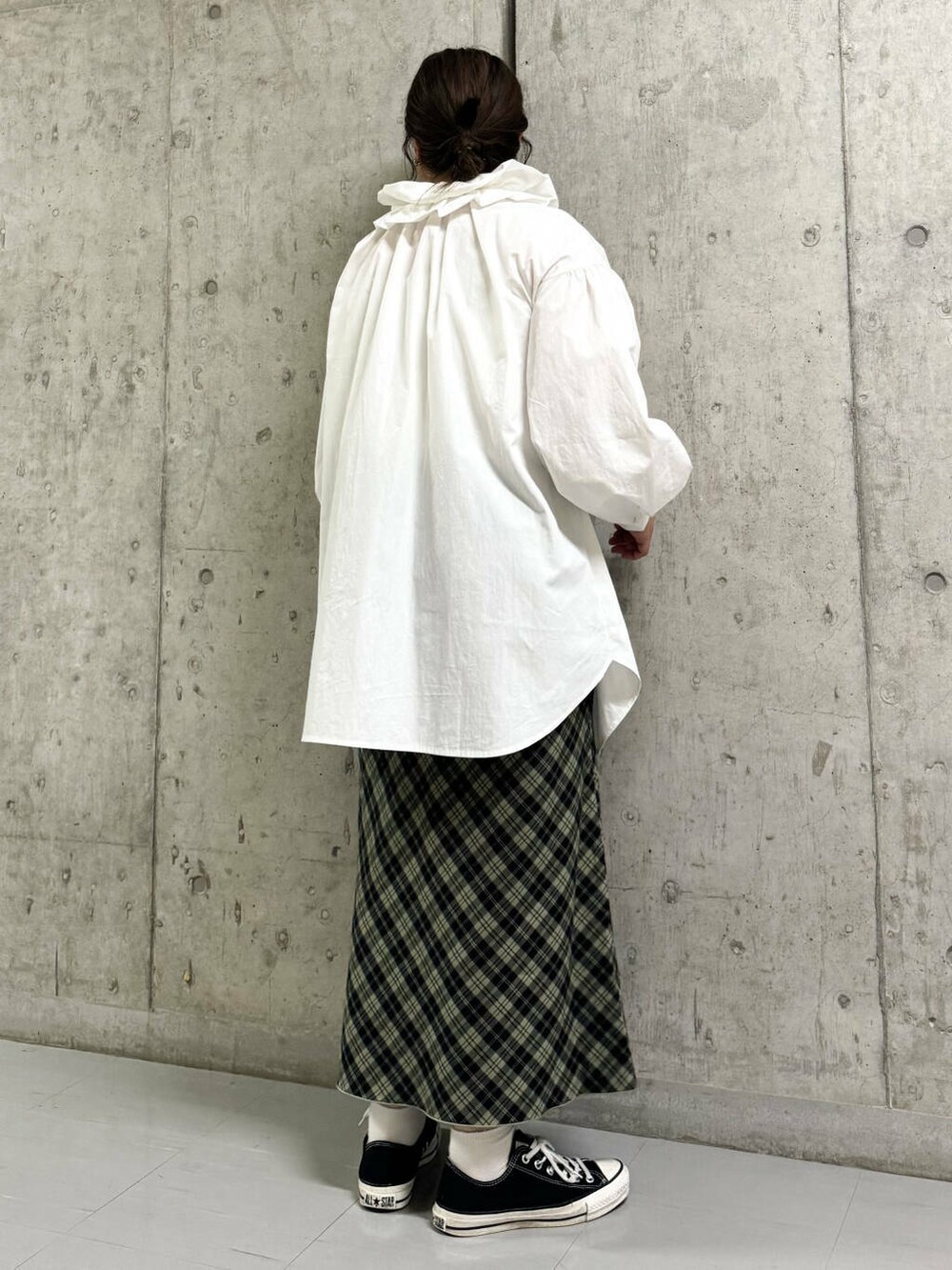 ホワイト系のワンピース、グリーン系のスカートを着用したレディースの秋コーディネートの2枚目の写真