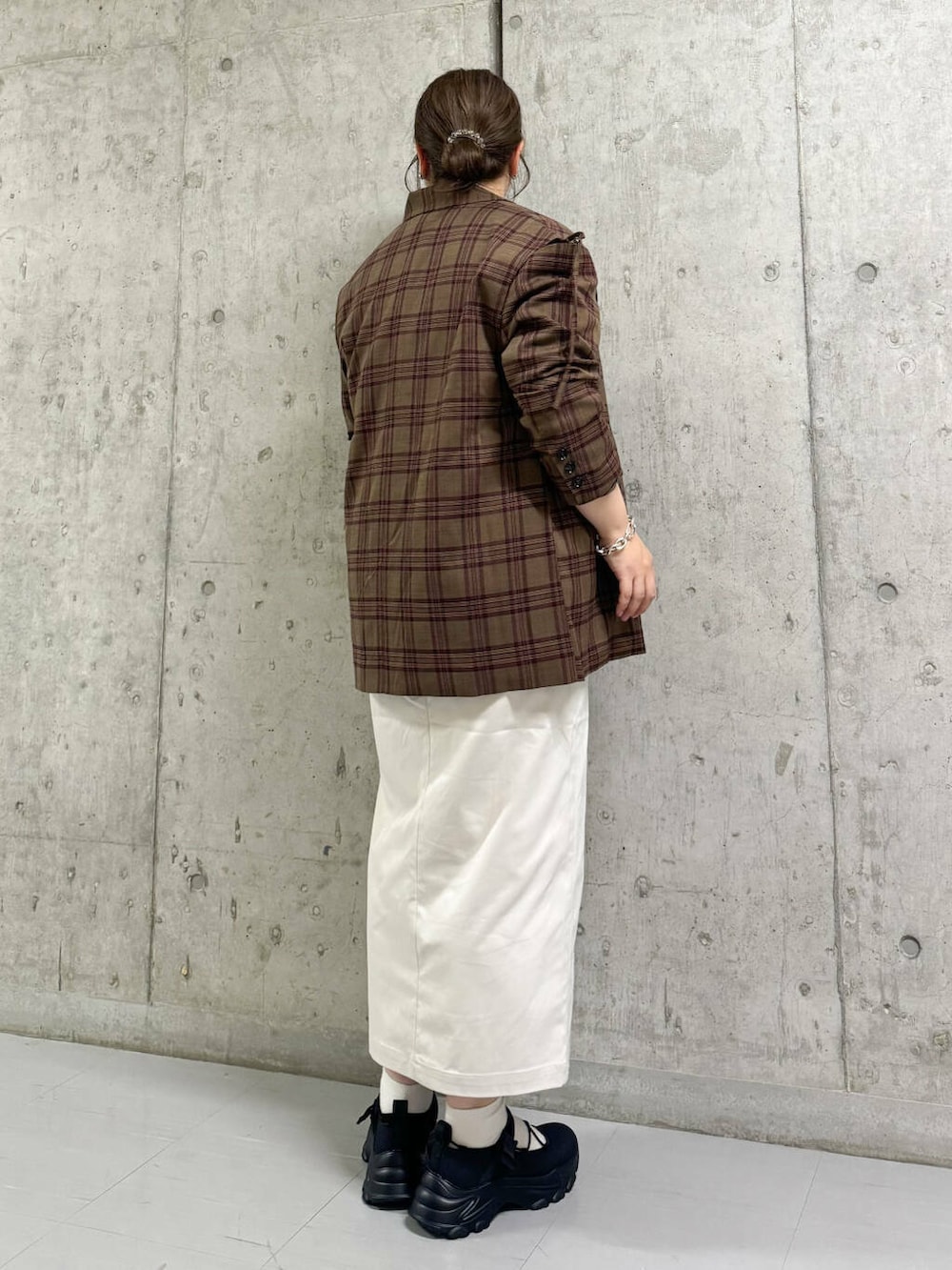 ベージュ系のスカート、ブラック系のスニーカー、レッド系のテーラードジャケットを着用したレディースの秋コーディネートの3枚目の写真