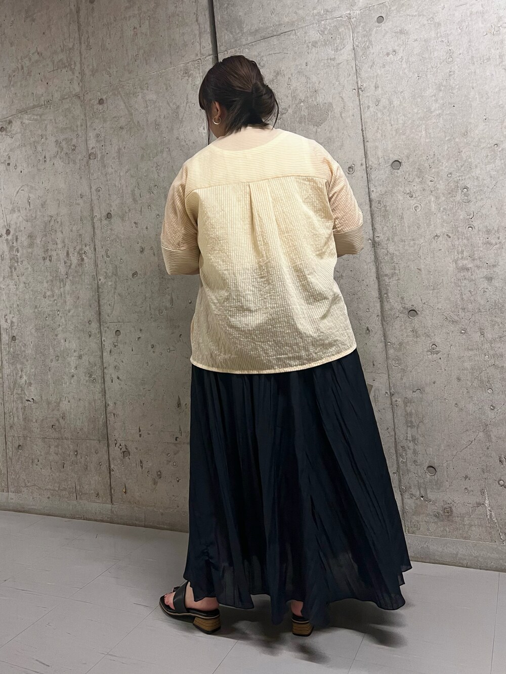 ベージュ系のシャツ/ブラウス、ブルー系のスカート、ブラック系のサンダルを着用したレディースの夏コーディネートの3枚目の写真