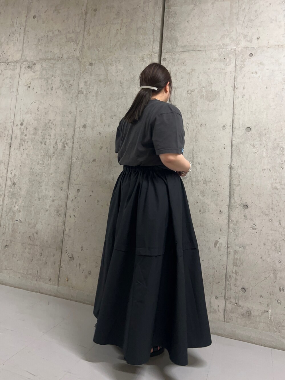ブラック系のスカートを着用したレディースの夏コーディネートの2枚目の写真