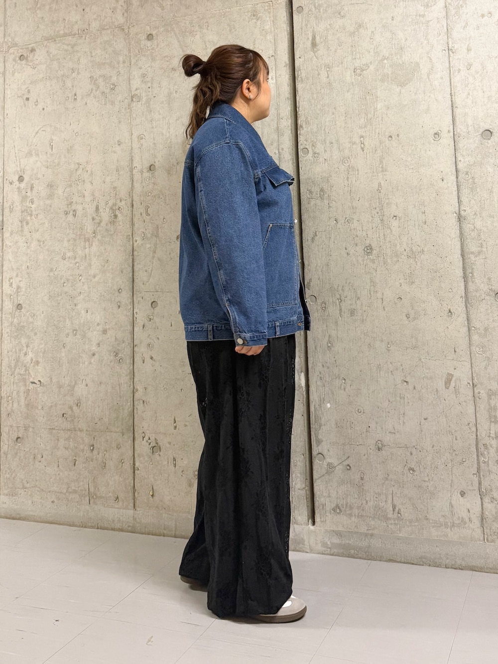 ブルー系のブルゾン、ブラック系のその他パンツを着用したレディースの春コーディネートの2枚目の写真