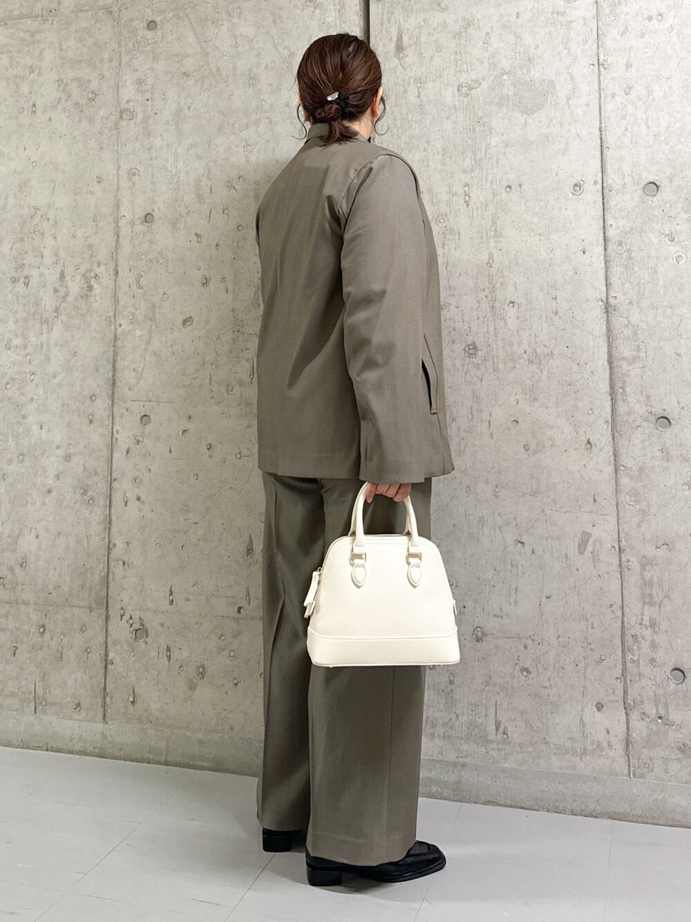 ブラウン系のスラックス、ブラウン系のテーラードジャケット、ホワイト系のシャツ/ブラウスを着用したレディースの春コーディネートの3枚目の写真