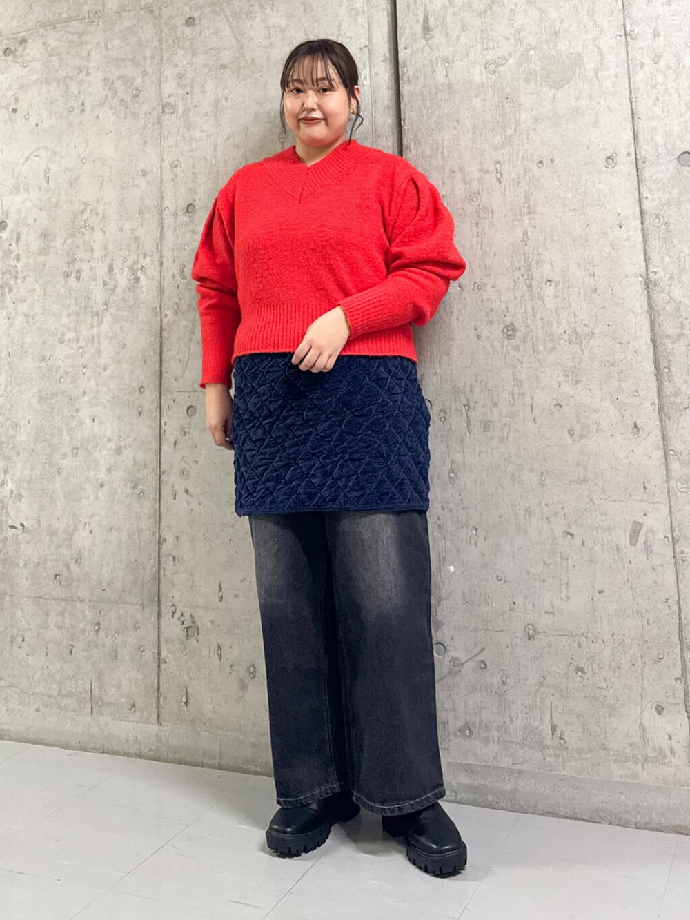 ブルー系のステンカラーコート、ブラック系のブーツ、ブラック系のデニムパンツを着用したレディースの冬コーディネートの2枚目の写真