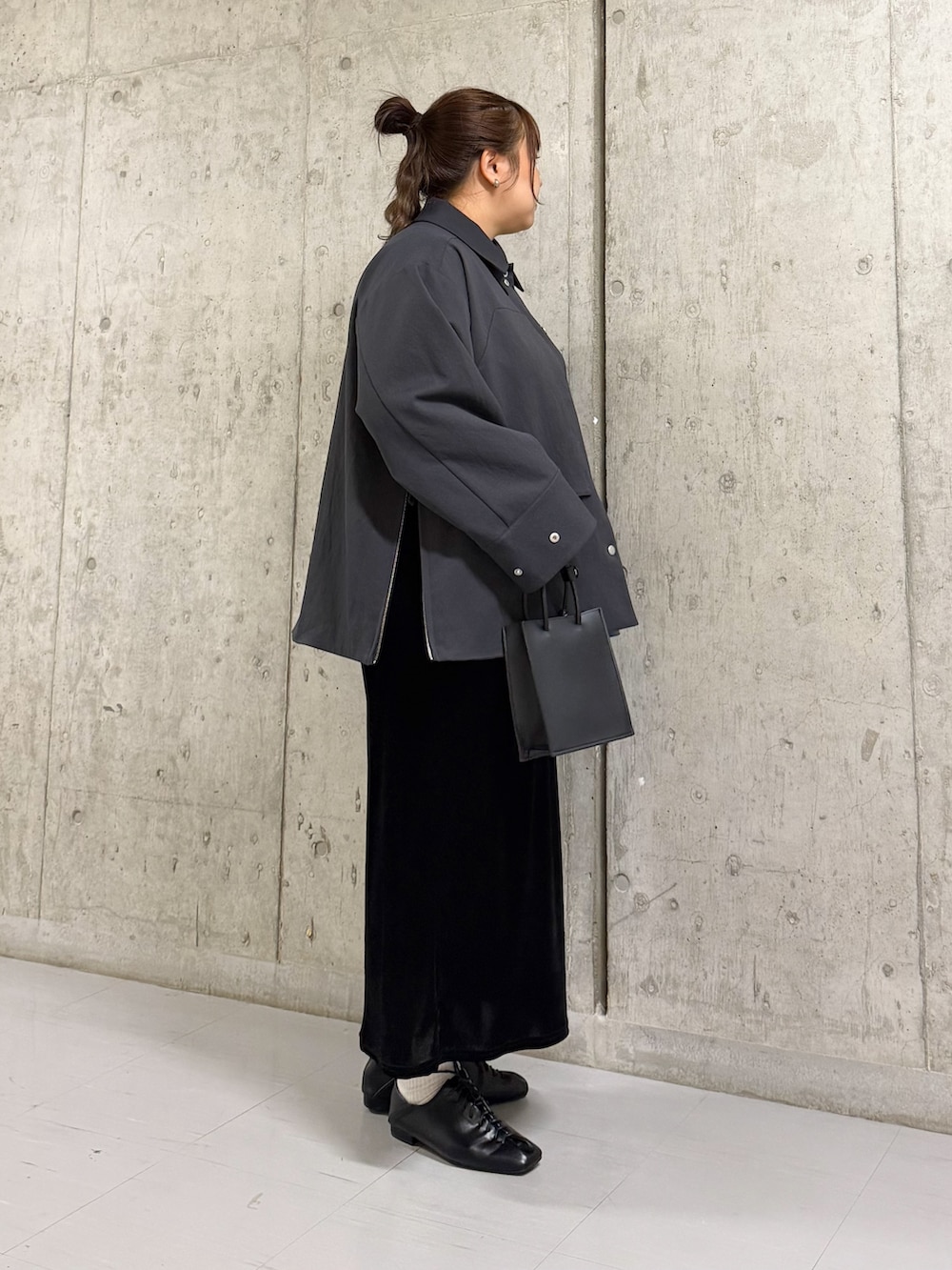 グレー系のその他アウター、ブラック系のワンピース、ブラック系のハンドバッグを着用したレディースの春コーディネートの2枚目の写真