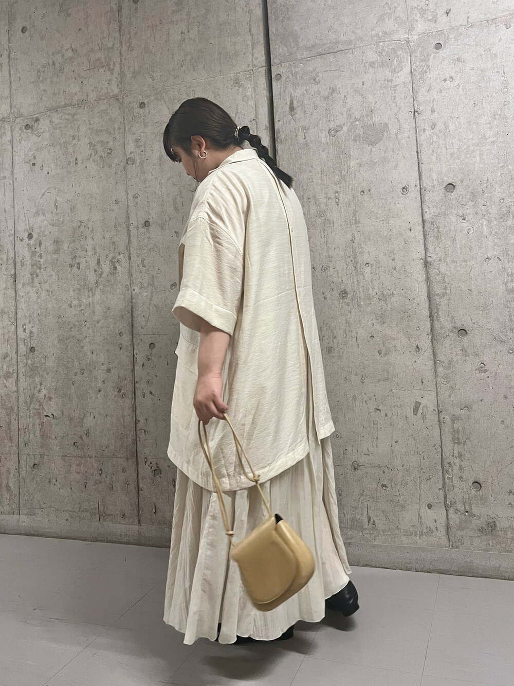 ベージュ系のシャツ/ブラウス、グレー系のスカート、ベージュ系のショルダーバッグを着用したレディースの夏コーディネートの2枚目の写真