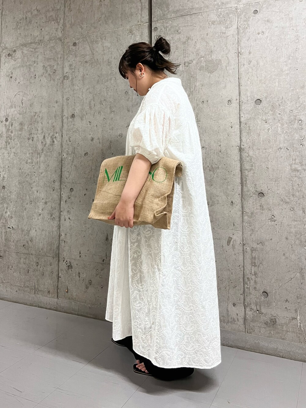 ホワイト系のワンピース、ブラック系のサンダル、ベージュ系のバッグを着用したレディースの春コーディネートの2枚目の写真