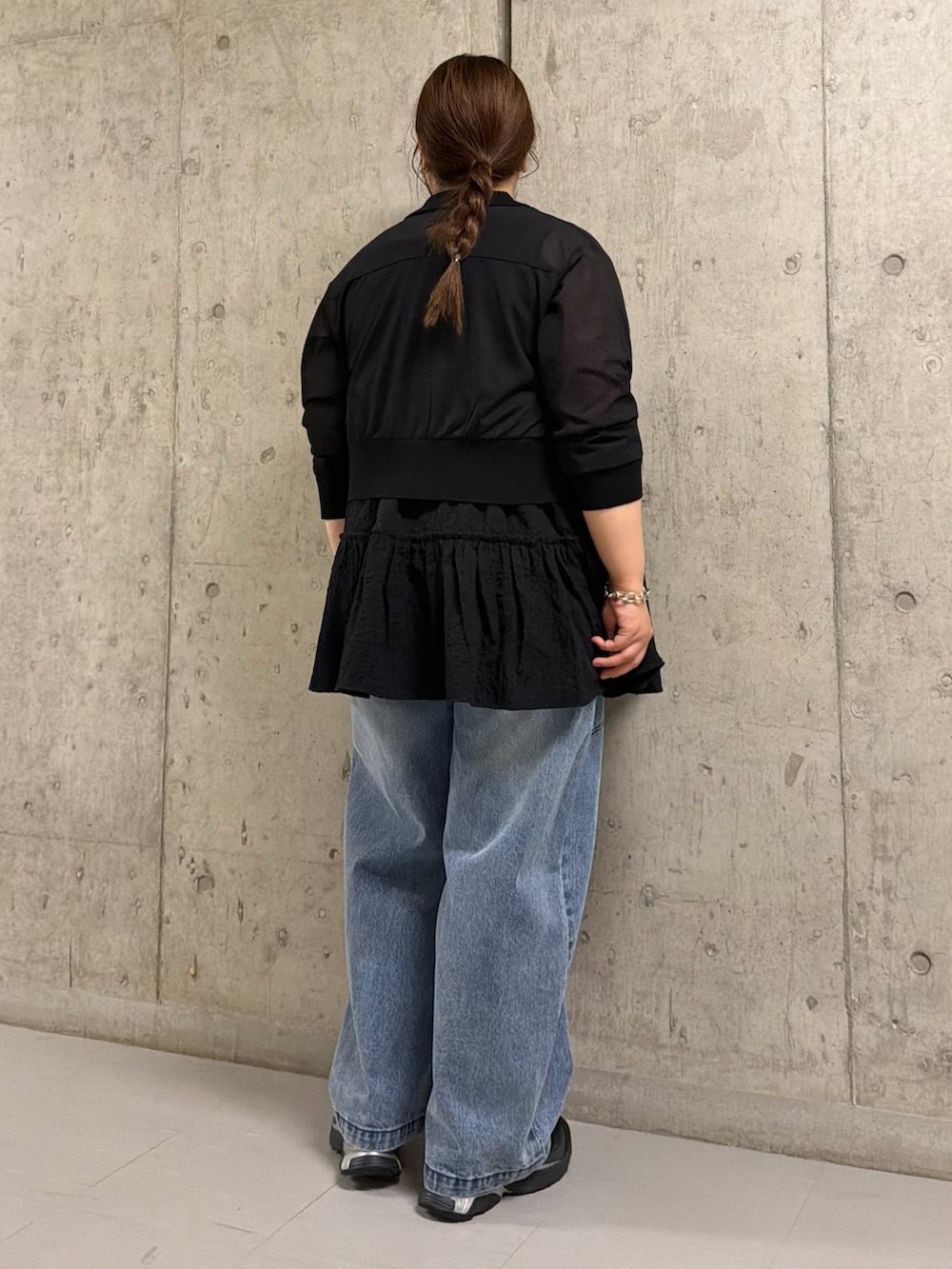 ブラック系のシャツ/ブラウス、ブラック系のチュニック、ブルー系のデニムパンツを着用したレディースの春コーディネートの2枚目の写真
