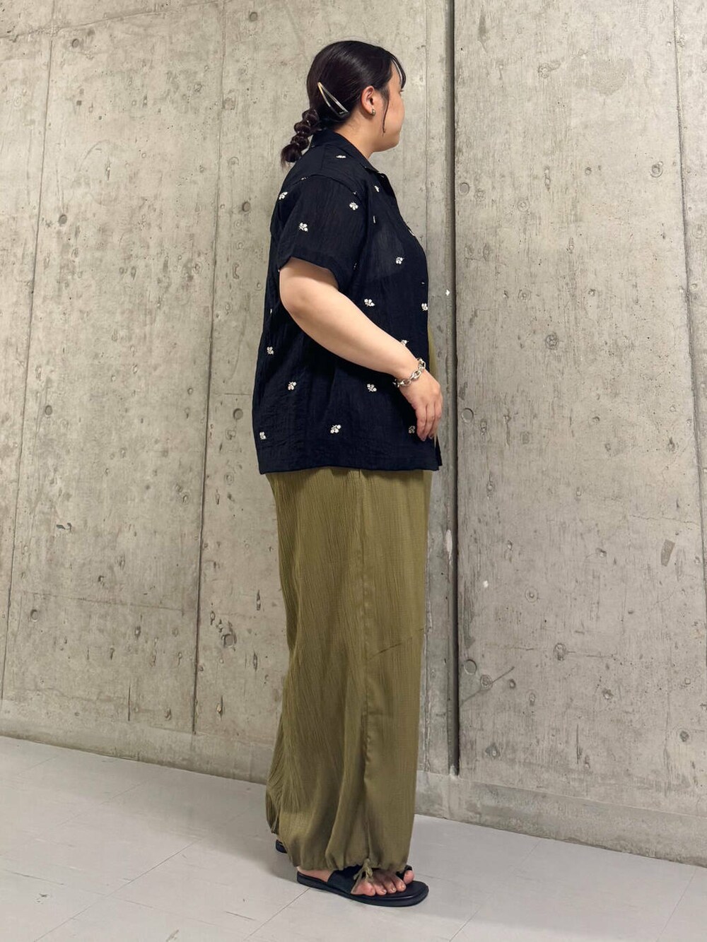 ブラック系のサンダル、グリーン系のサロペット/オーバーオール、ブラック系のシャツ/ブラウスを着用したレディースの夏コーディネートの2枚目の写真