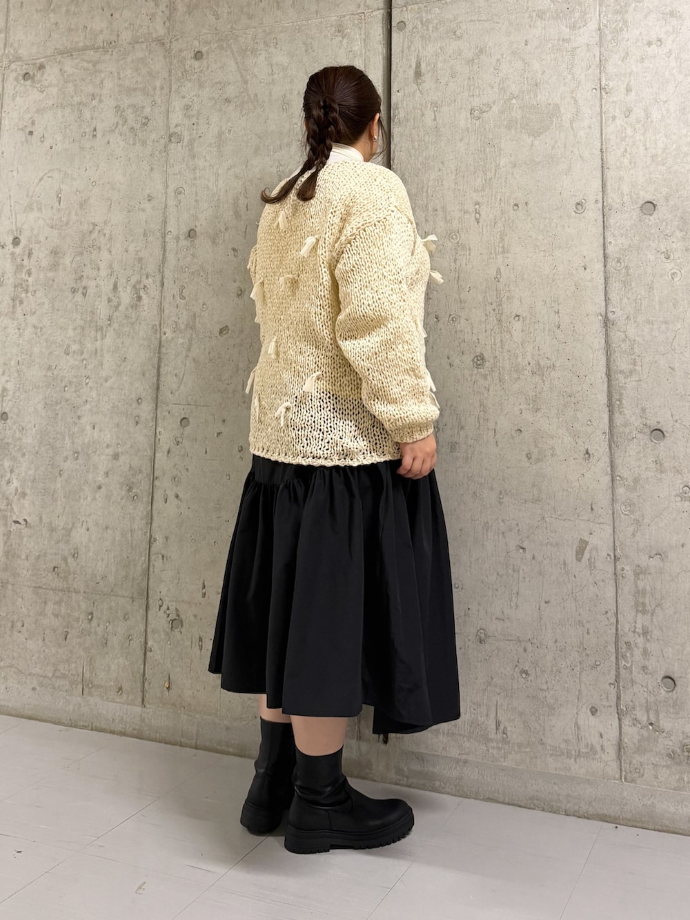 ホワイト系のTシャツ/カットソー、ホワイト系のニット/セーター、ブラック系のスカートを着用したレディースの冬コーディネートの2枚目の写真