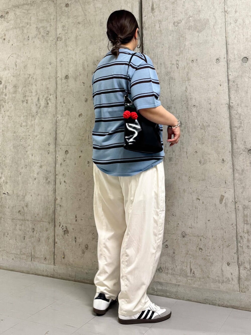 ブラック系のショルダーバッグ、ホワイト系のその他パンツ、ブルー系のニット/セーターを着用したレディースの春コーディネートの3枚目の写真