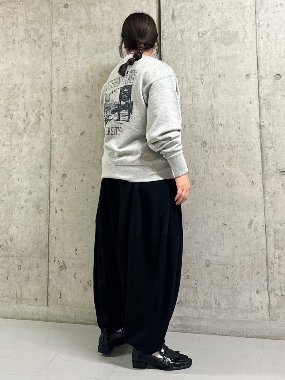 グレー系のスウェット、ブラック系のその他パンツ、ブラック系のローファーを着用したレディースの秋コーディネートの2枚目の写真