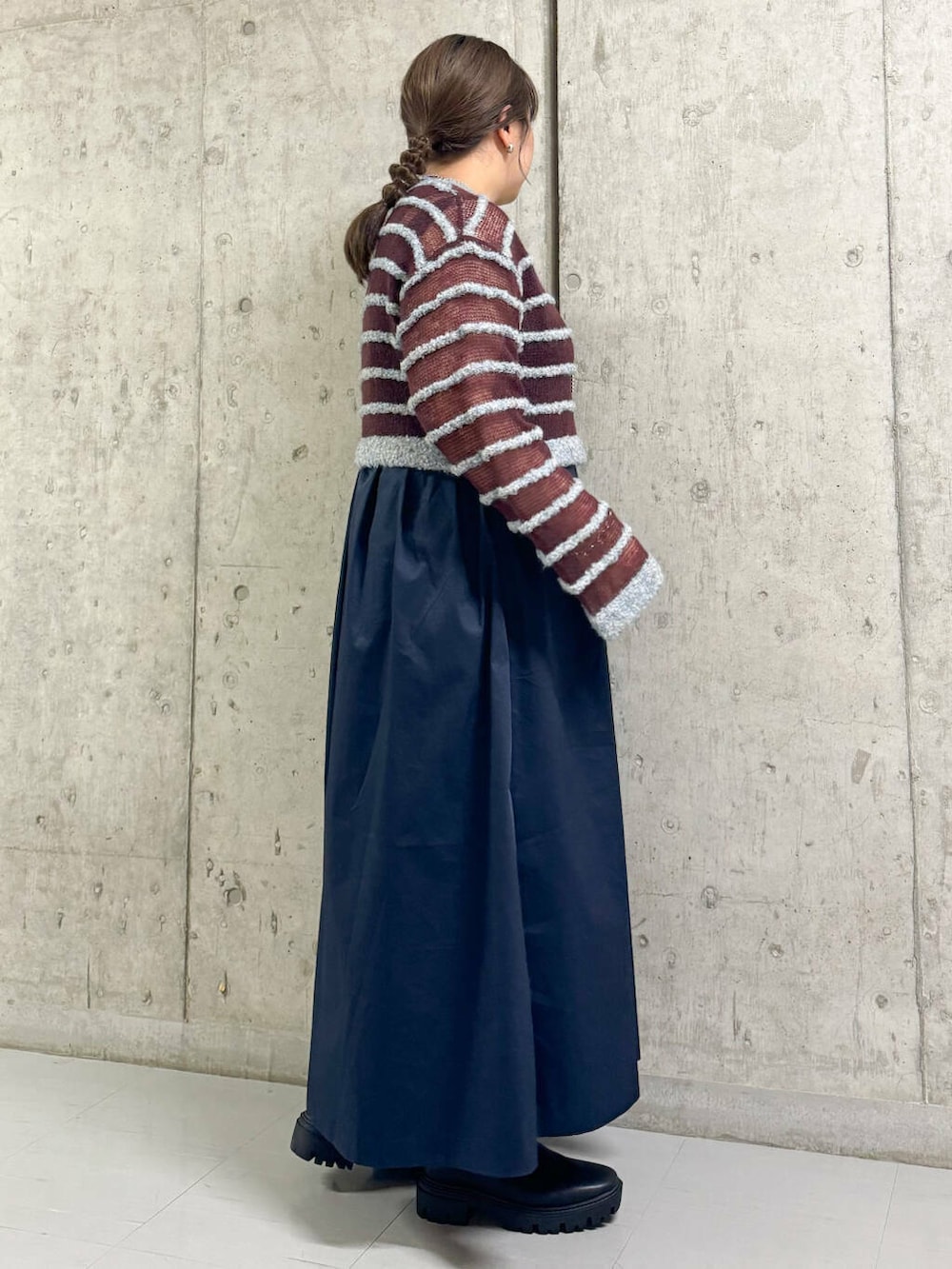 ブラック系のブーツ、ブルー系のワンピース、ブルー系のニット/セーターを着用したレディースの秋コーディネートの2枚目の写真