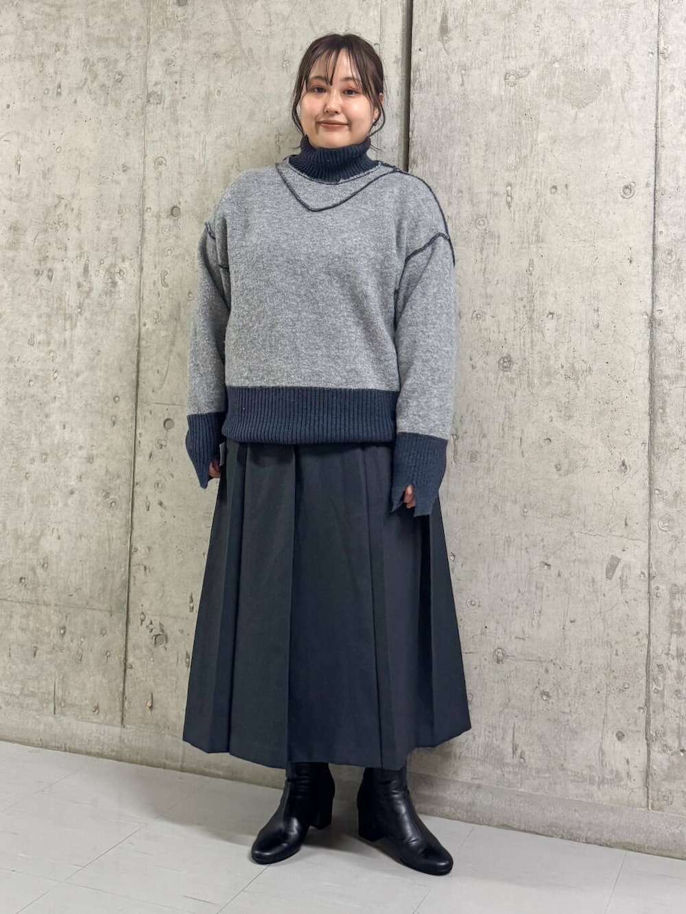 ブラック系のブーツ、グレー系のワンピース、ブルー系のニット/セーターを着用したレディースの冬コーディネートの2枚目の写真