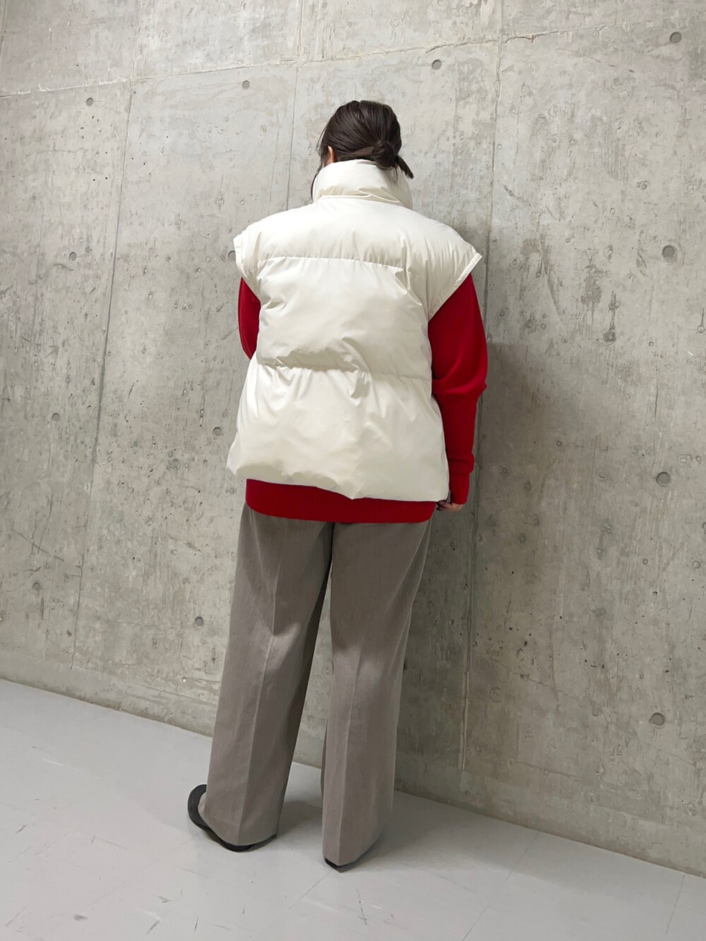 ブラウン系のスラックス、ホワイト系のダウンジャケット/コート、レッド系のニット/セーターを着用したレディースの秋コーディネートの5枚目の写真