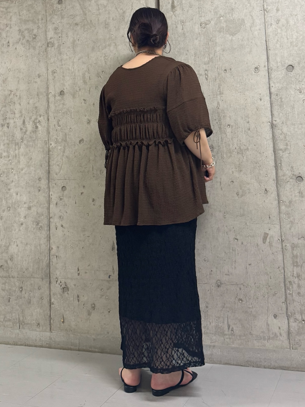 ブラウン系のシャツ/ブラウス、ブラック系のスカート、ブラック系のサンダルを着用したレディースの夏コーディネートの3枚目の写真