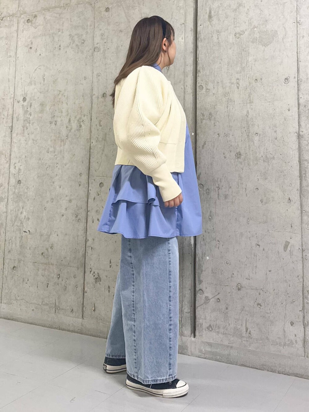 ブルー系のワンピース、ブルー系のデニムパンツ、ホワイト系のカーディガン/ボレロを着用したレディースの冬コーディネートの2枚目の写真