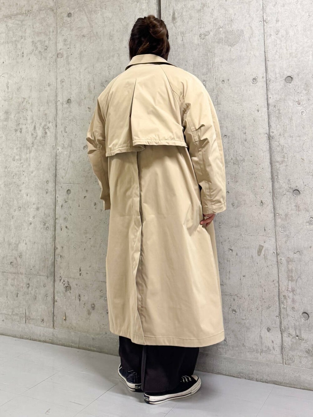 ホワイト系のニット/セーター、ブラウン系のその他パンツ、ベージュ系のステンカラーコートを着用したレディースの冬コーディネートの4枚目の写真