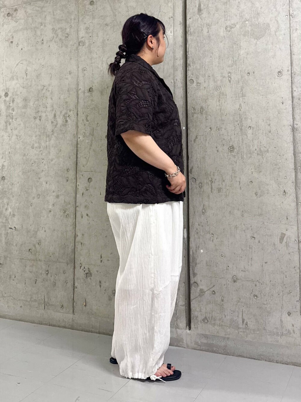 ブラック系のサンダル、ホワイト系のサロペット/オーバーオール、ブラウン系のシャツ/ブラウスを着用したレディースの夏コーディネートの2枚目の写真