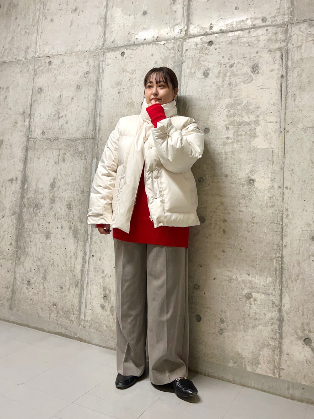ブラウン系のスラックス、ホワイト系のダウンジャケット/コート、レッド系のニット/セーターを着用したレディースの秋コーディネートの2枚目の写真