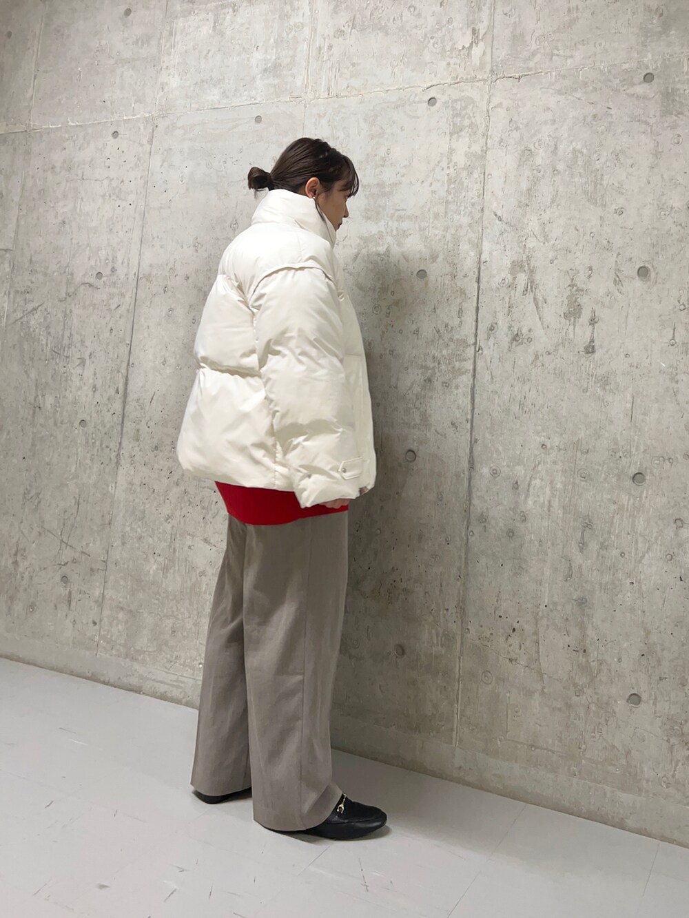 ブラウン系のスラックス、ホワイト系のダウンジャケット/コート、レッド系のニット/セーターを着用したレディースの秋コーディネートの4枚目の写真