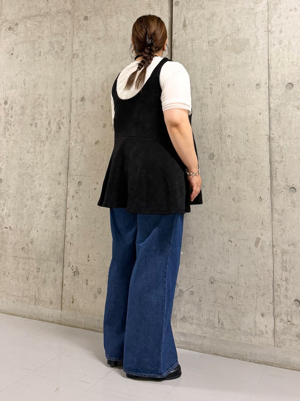 ブラック系のワンピース、ブルー系のデニムパンツを着用したレディースの夏コーディネートの2枚目の写真