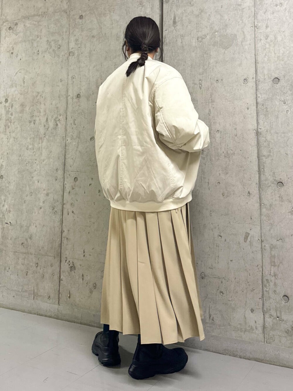 ブラック系のブーツ、ホワイト系のMA-1、ベージュ系のワンピースを着用したレディースの秋コーディネートの3枚目の写真