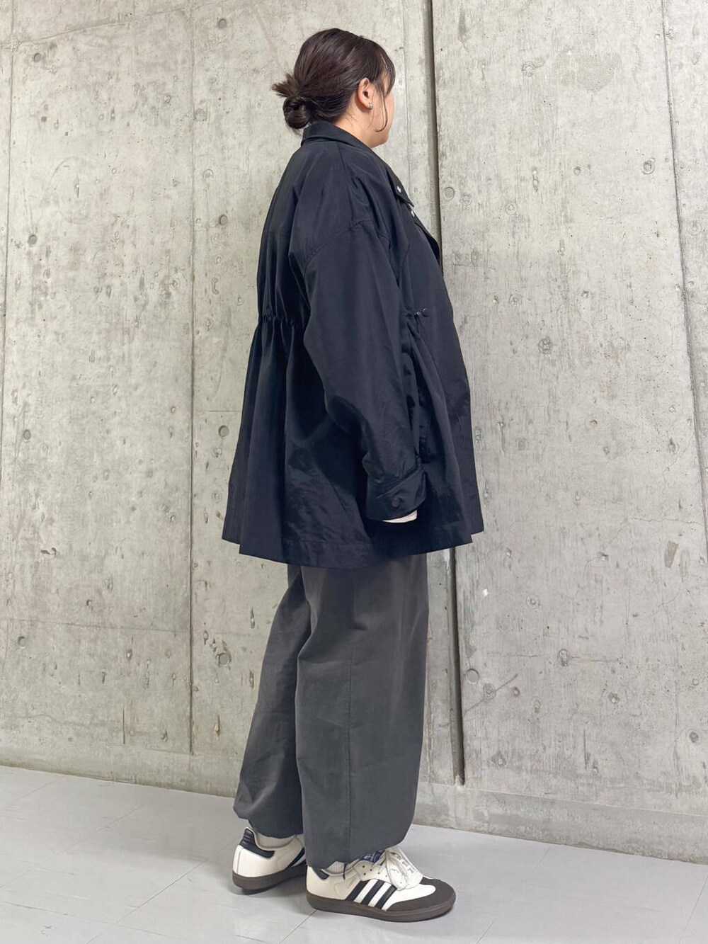 グレー系のその他パンツ、ブラック系のナイロンジャケット、ピンク系のTシャツ/カットソーを着用したレディースの春コーディネートの3枚目の写真