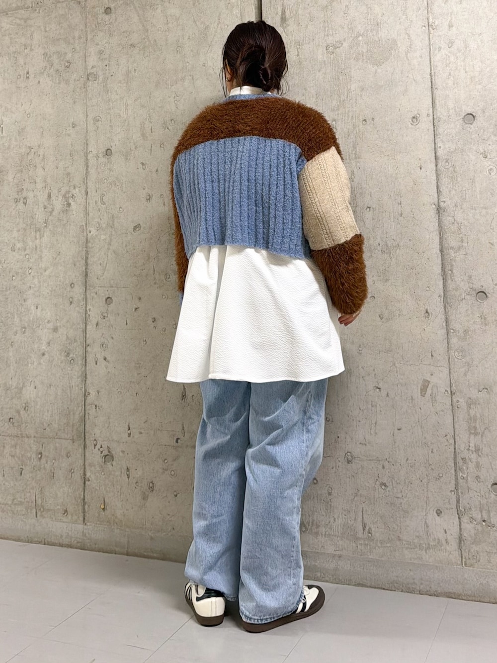 ブルー系のカーディガン/ボレロ、ホワイト系のシャツ/ブラウス、ブルー系のデニムパンツを着用したレディースの秋コーディネートの2枚目の写真