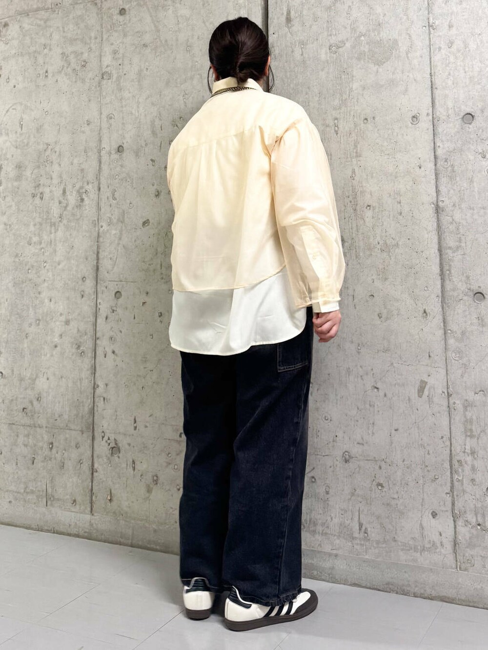 ブラック系のデニムパンツ、ベージュ系のシャツ/ブラウスを着用したレディースの春コーディネートの3枚目の写真